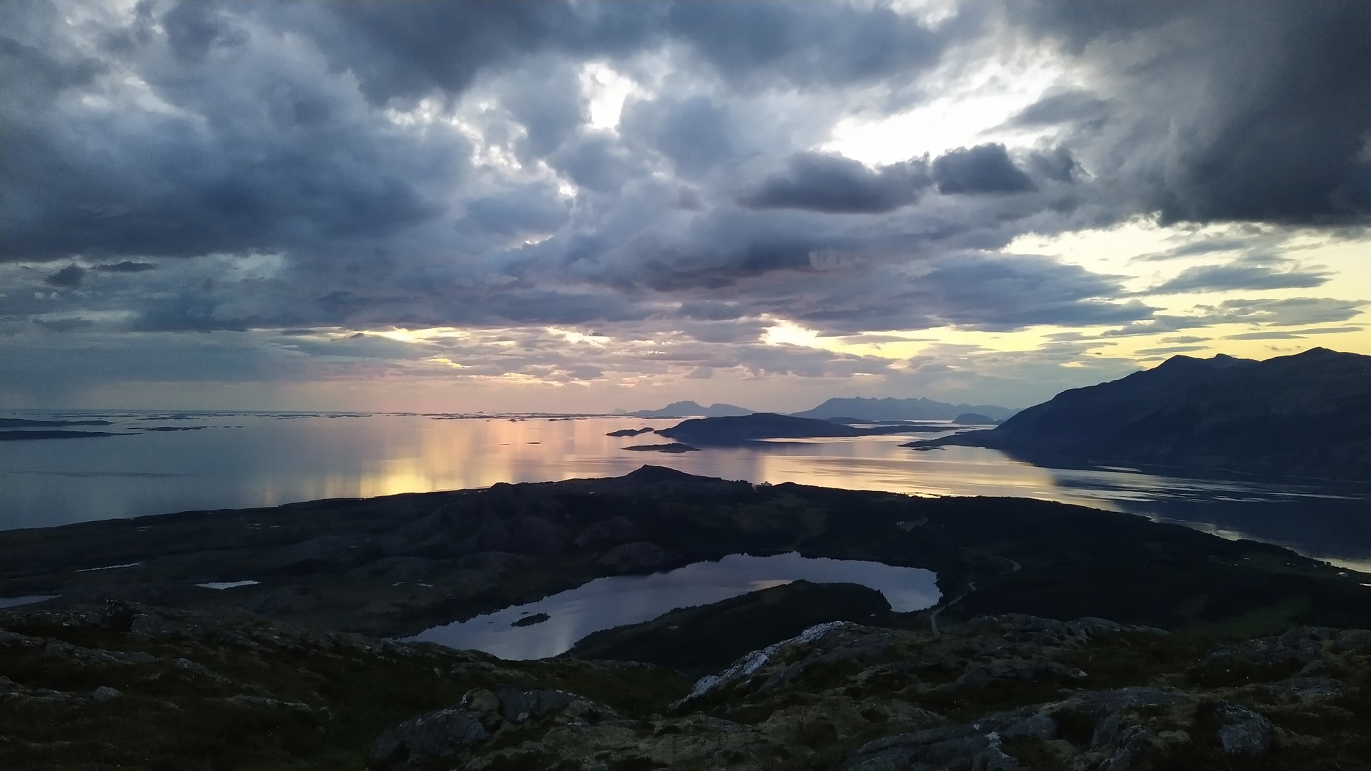 Dramatisk himmel over fjell, fjord og stille fjellvann